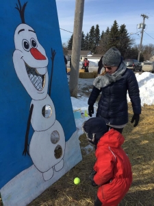 A child tries to get the ball into an Olaf the Snowman game board