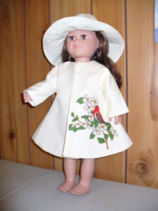 18 inch doll wearing custom white doll dress and hat