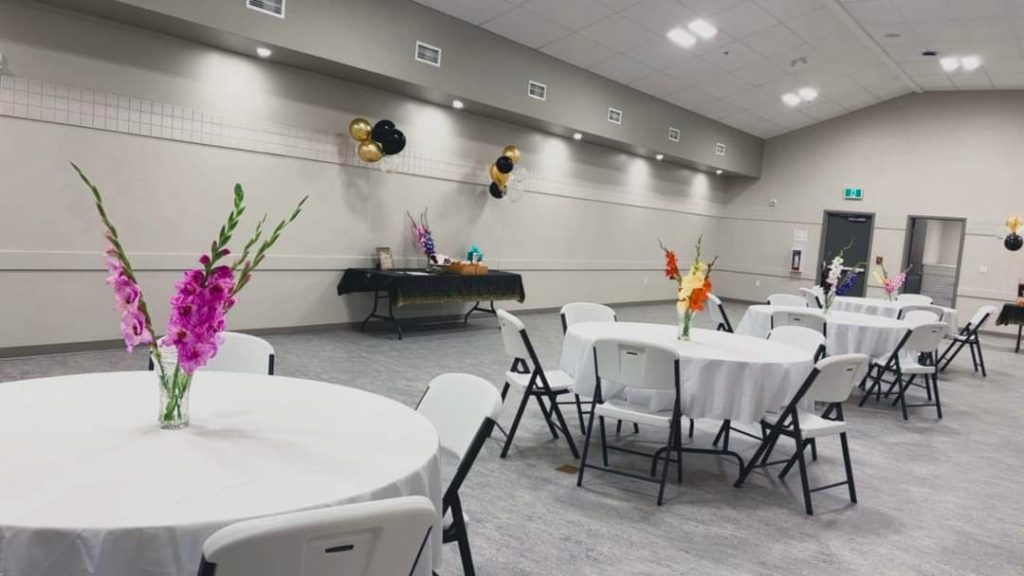 An event set up in the banquet hall including round table seating and a side table